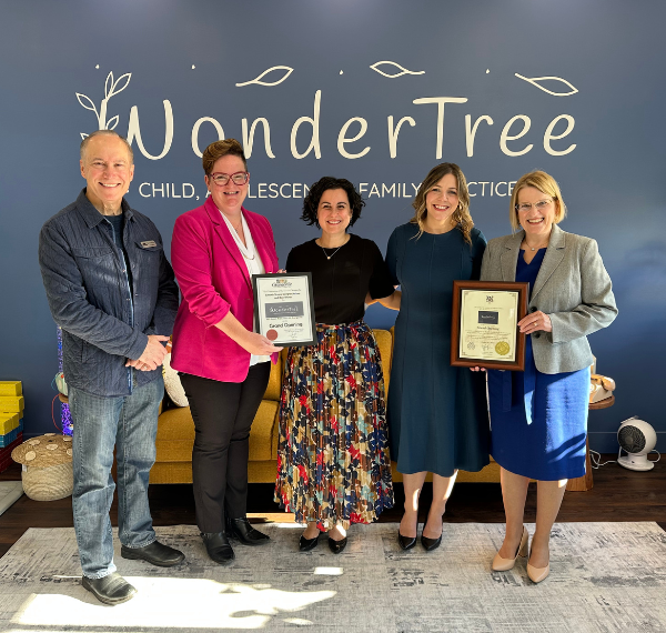 A group of people standing for a photo at a business grand opening